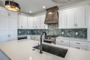A new home kitchen with a hidden pantry and green tile backsplash.