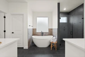 New construction primary bathroom with dark tile accents